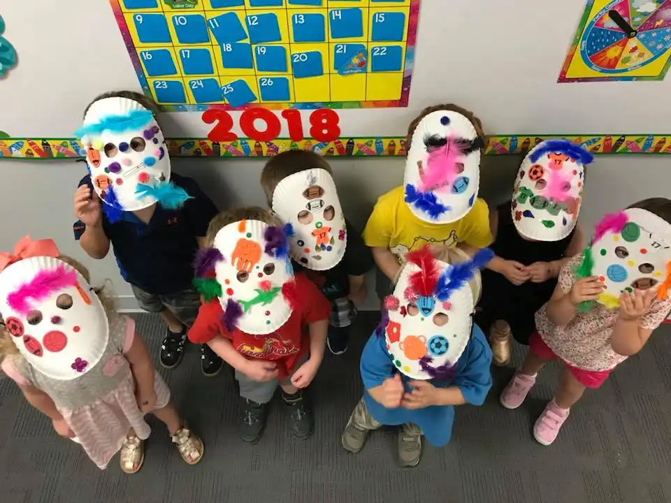 A group of young children wearing paper hand painted masks at Early learning center Annapolis MD